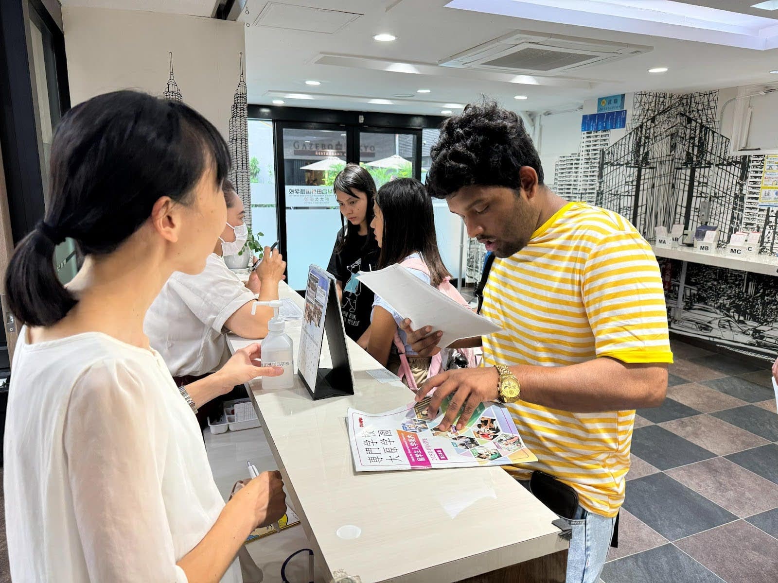 Staff assisting international student with documents